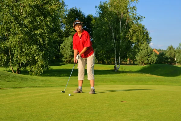 Golf, vrouw golfspeler stak de bal in het gat — Stockfoto