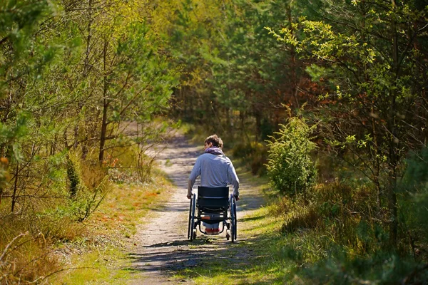 Behinderte Rollstuhlfahrerin im Wald lizenzfreie Stockbilder
