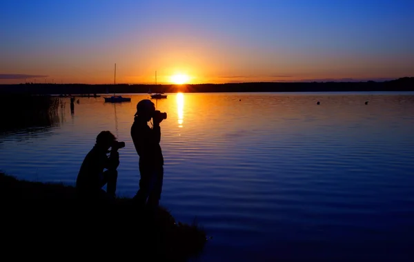 Photographers and sunset over the lake — Stock Photo, Image