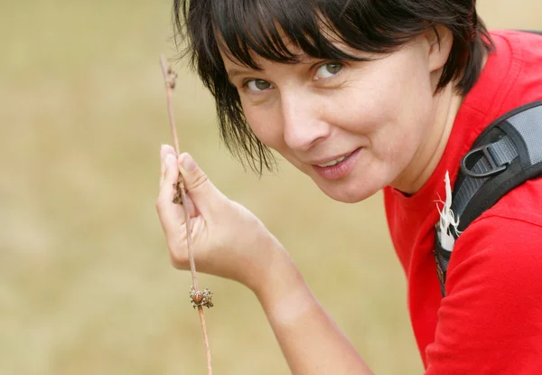 Woman in a red T-shirt and spider on a stick — Stock Photo, Image