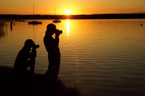 Photographers and sunset over the lake — Stock Photo, Image