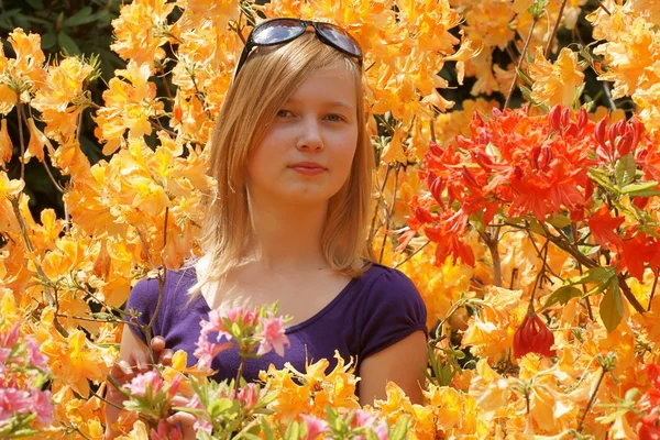 Teenage girl sniffing the flowers Azaleas — Stock Photo, Image