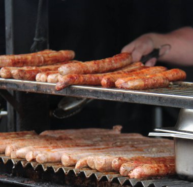 Uzun sosisler dışarıda ızgara fırınında pişiriliyor..
