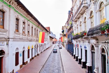 Streets of Cuenca Ecuador during the festivities with city flags clipart