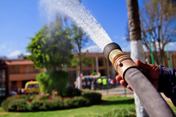 Bombeiro usando mangueira de água para prevenir o fogo — Fotografia de Stock