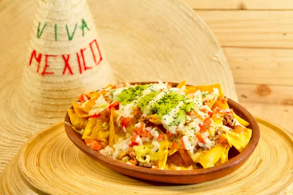 Plate of fresh nachos with a jalapeno cheese sauce — Stock Photo, Image