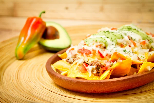 Plate of fresh nachos with a jalapeno cheese sauce — Stock Photo, Image