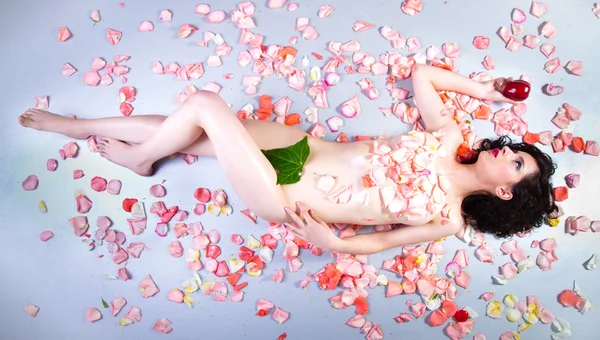 Hermosa mujer desnuda joven con rosas que representan la belleza — Foto de Stock