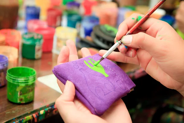 Hand painting a wallet with paintbrush — Stock Photo, Image
