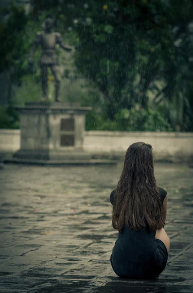 Mulher sentada na chuva, com pouco vestido preto — Fotografia de Stock