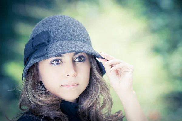 Belle brune en chapeau sur fond de parc vert — Photo