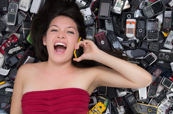 Mulher em cima de uma pilha de telemóveis — Fotografia de Stock