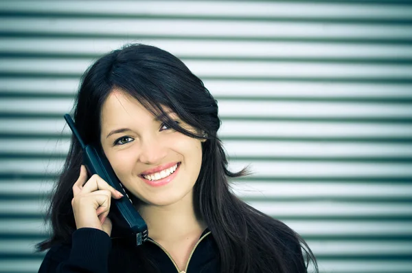 Una mujer joven hablando en un teléfono inalámbrico doméstico . —  Fotos de Stock