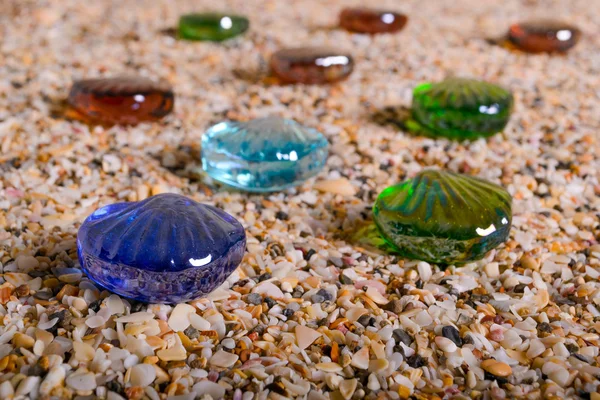 Coquilles de mer en verre avec du sable comme fond — Photo