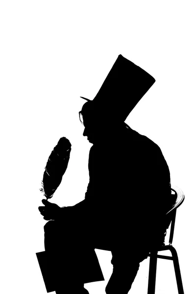 Silhouette man sitting on a stool while writing — Stock Photo, Image