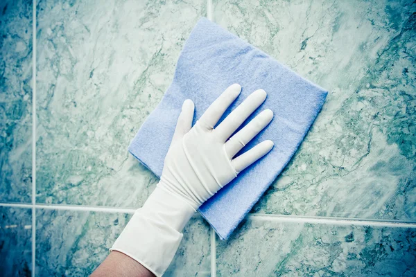 Mão feminina telhas da cozinha de limpeza com esponja — Fotografia de Stock