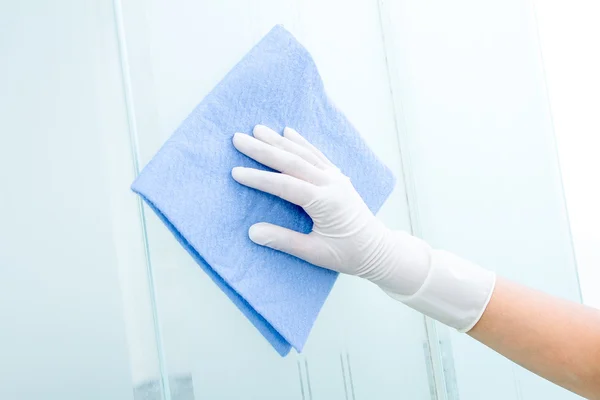 Hand en de handschoen met blauwe spons reinigen van glas — Stockfoto