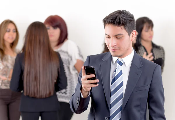 Homem hispânico usando um celular com colegas — Fotografia de Stock