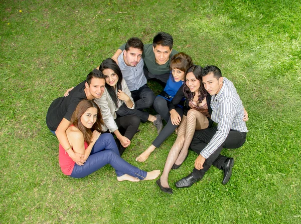 Feliz grupo de estudiantes sentados en el parque — Foto de Stock