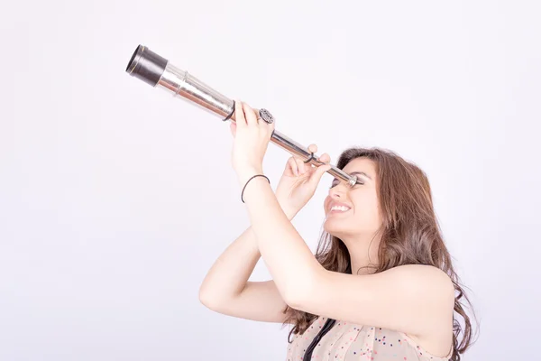 Молодая женщина с помощью телескопа — стоковое фото