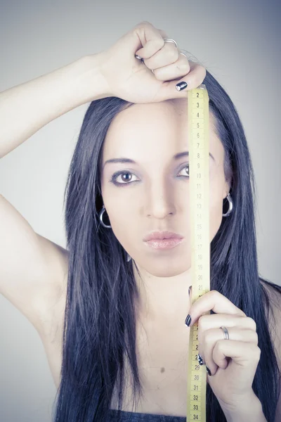 Mulher tem fita métrica em torno de sua cabeça posando — Fotografia de Stock