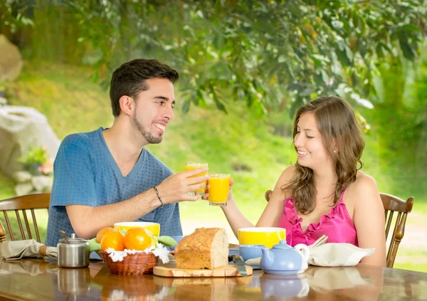 Paar frühstückt zu Hause mit Garten im Hintergrund — Stockfoto