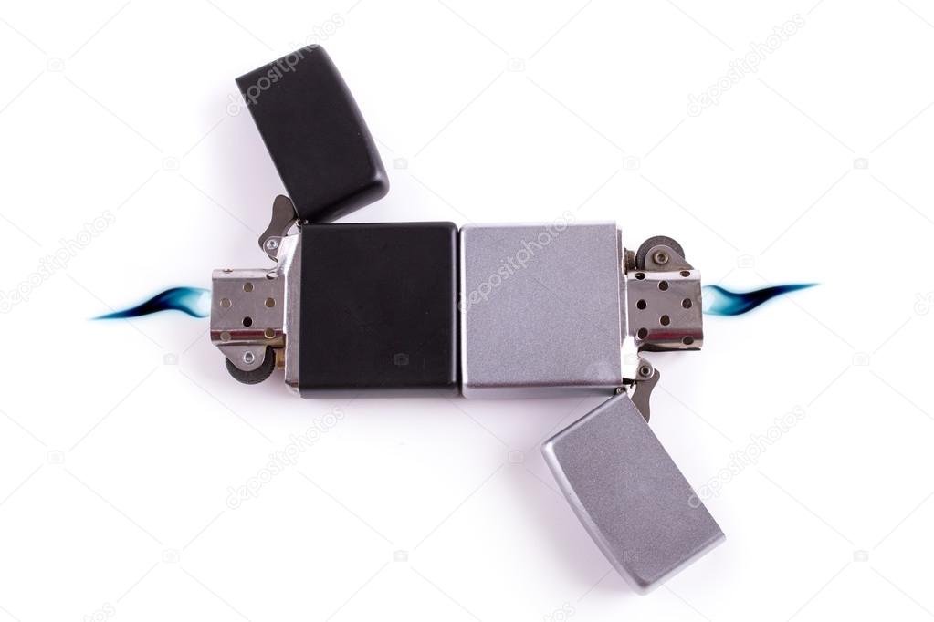 Silver metal lighters on white background with blue flame.