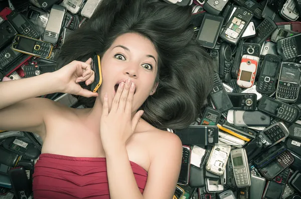 Mulher em cima de uma pilha de telemóveis — Fotografia de Stock