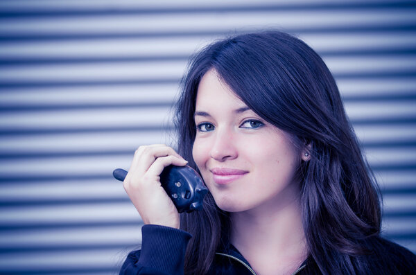 Businesswoman in warehouse using walkie-talkie