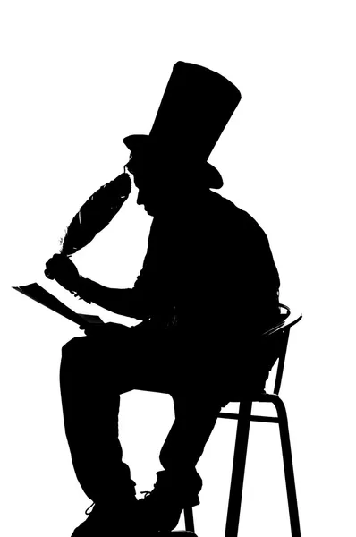 Silhouette man sitting on a stool while writing — Stock Photo, Image