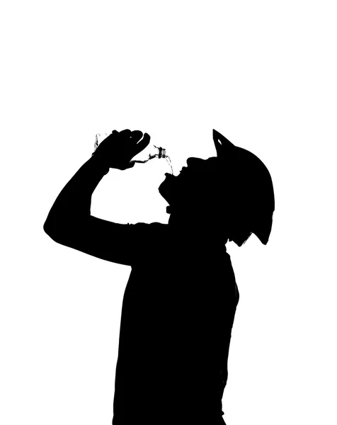 Silhueta de um homem bebe água para saciar a sede — Fotografia de Stock