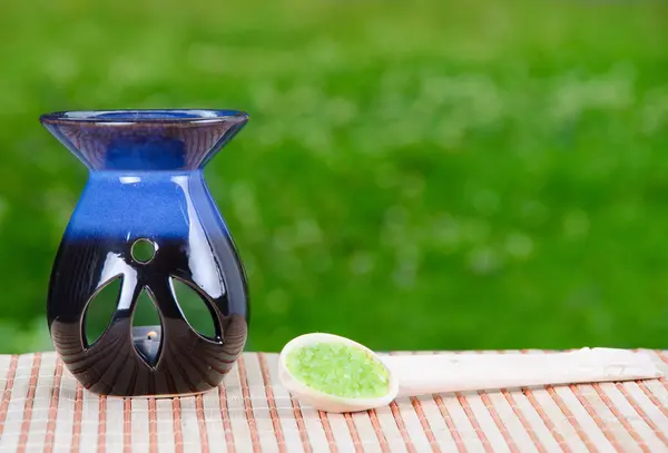 Primer plano de una sal de baño verde y una vela —  Fotos de Stock