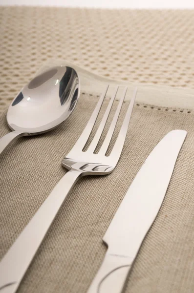 Knife, fork and spoon with linen serviette — Stock Photo, Image