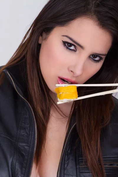 Beautiful young woman eating sushi roll — Stock Photo, Image