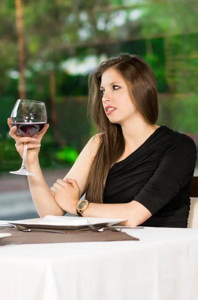 Nettes Mädchen und Weinglas in einem Restaurant — Stockfoto