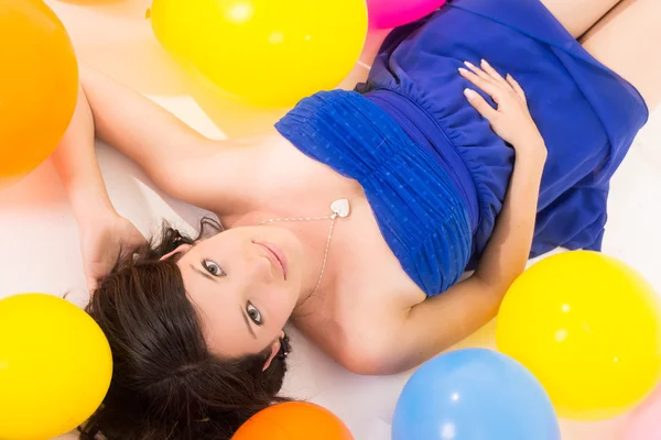 Sexy young woman lying on floor among balloons — Stock Photo, Image