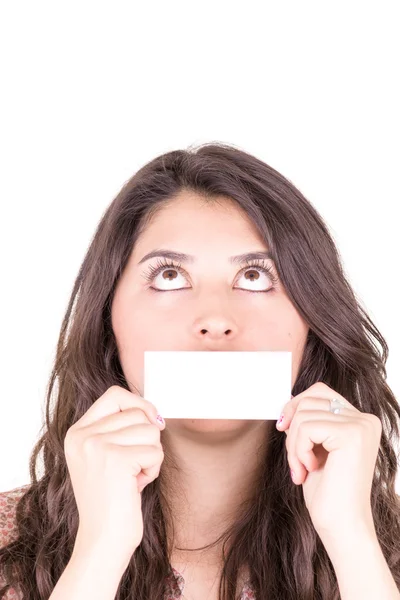 Mujer joven sosteniendo una tarjeta de visita en blanco delante de su boca . —  Fotos de Stock