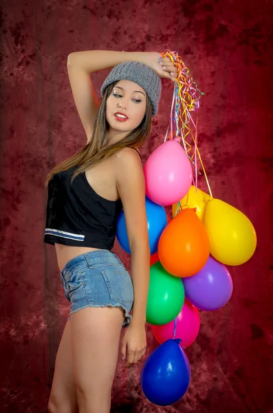Jonge vrouw met ballonnen om haar heen, studio schoot — Stockfoto
