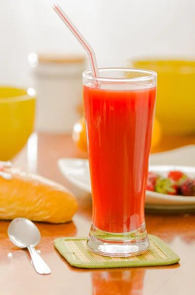 Breakfast and glass of red juice on wooden table — Stock Photo, Image