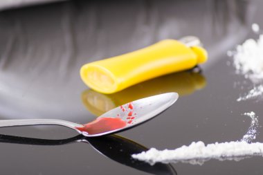 Uyuşturucu şırıngası ve pişirilmiş eroin.