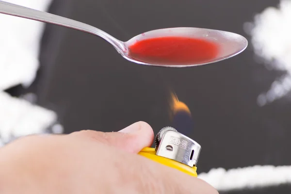 Riscaldamento di farmaci in un cucchiaio sopra la fiamma — Foto Stock