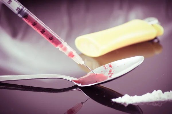 Drug syringe and cooked heroin on spoon — Stock Photo, Image