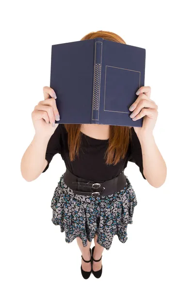 Ung kvinna som täcker hennes ansikte med bok — Stockfoto
