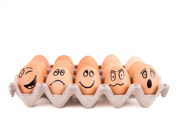 Lustige Gesichter auf braune Eier in einem Tablett gemalt — Stockfoto