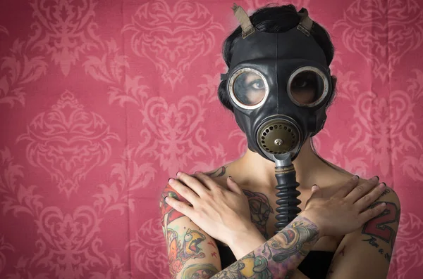 Femme sexy portant un masque à gaz munitions en fond rose — Photo