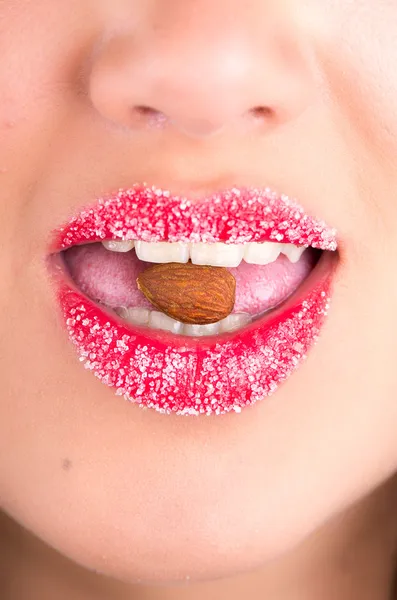 Primer plano de boca femenina comiendo almendras — Foto de Stock