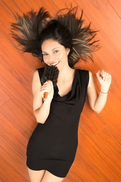 Happy attractive woman singing to comb on the floor — Stock Photo, Image