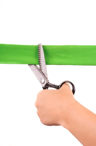 Manos cortando cinta verde con tijeras — Foto de Stock