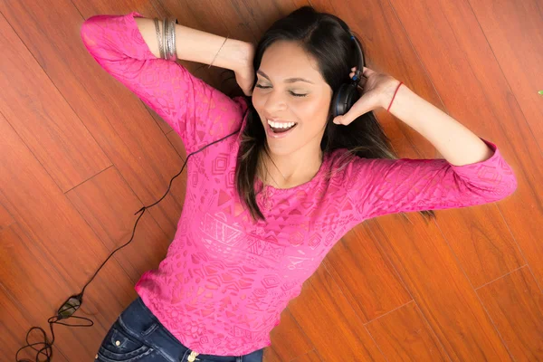 Mujer acostada en el suelo y escuchando música . —  Fotos de Stock