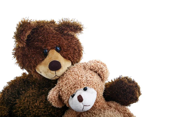 Two teddy bears, bigger and smaller, sitting close to each other like they are best friends. — Stock Photo, Image